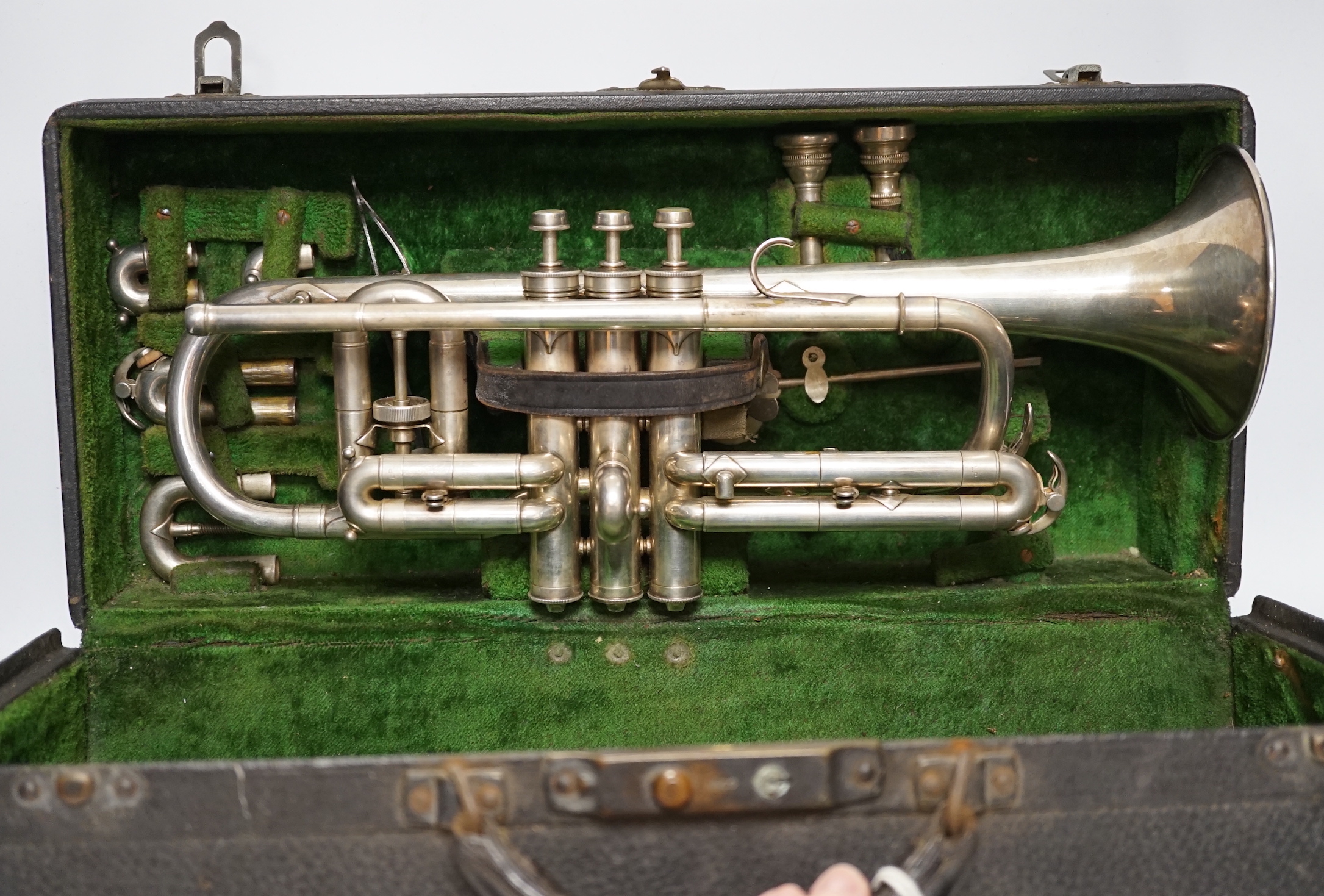 An Elkhart, Indiana No. 144989 trumpet, unusual trumpet with threaded fine adjust tuning slides, spare set of slides, two mouthpieces and two music lyres for marching, in a good fitted case, with a card boxed ‘maintenanc